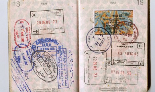 טיפים להוצאת אשרת עבודה / ויזה לרילוקיישן - תמונה של שני עמודי דרכון מלאים בחותמות ממדינות שונות